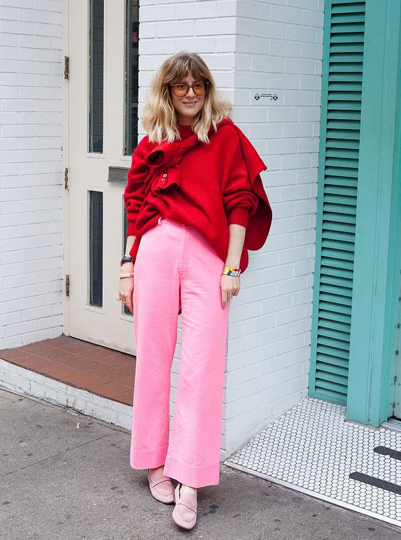 woman wearing a deep red sweater with bubblegum pink wide leg jeans and pink flats