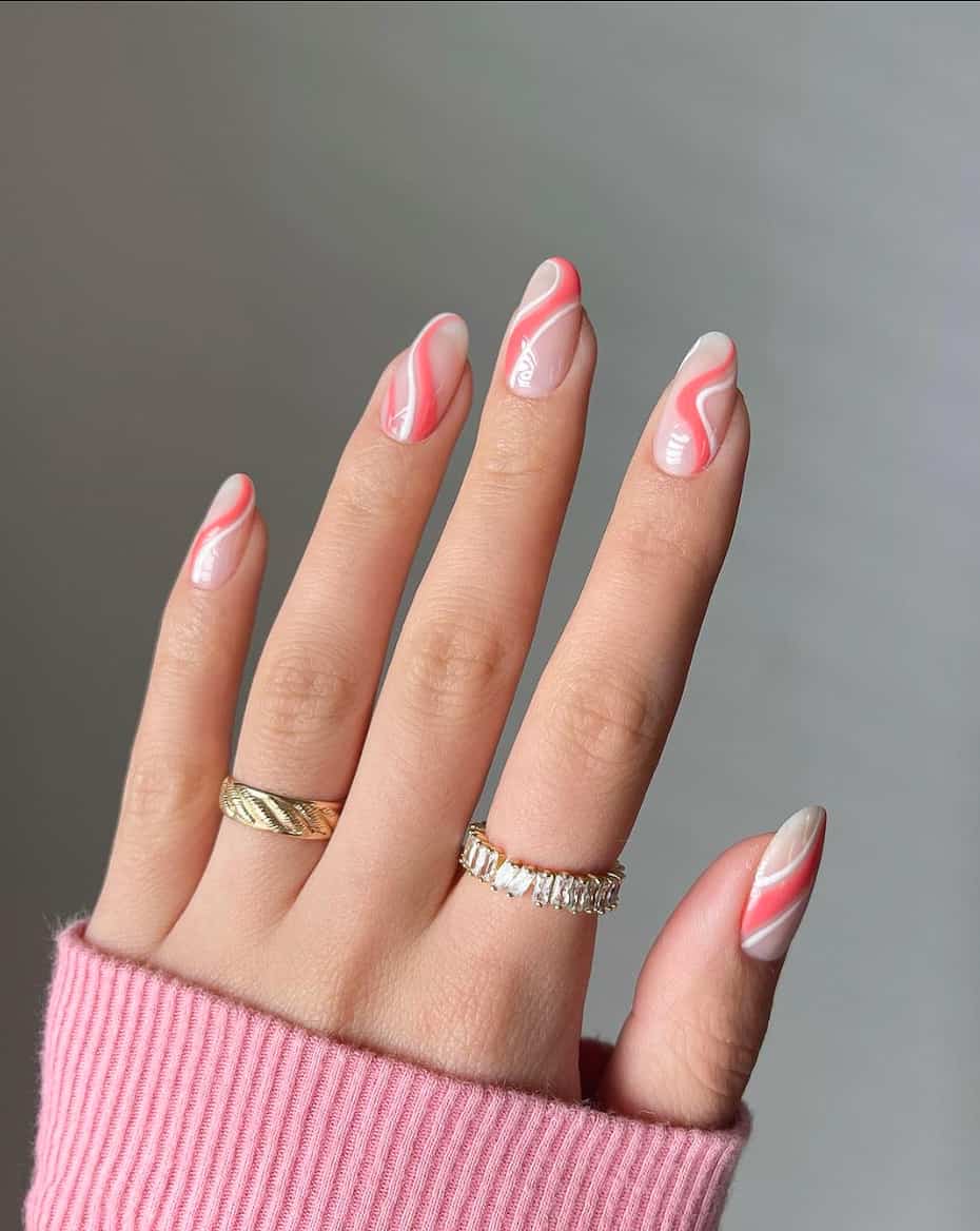 image of a hand with white and pink nail polish wave art