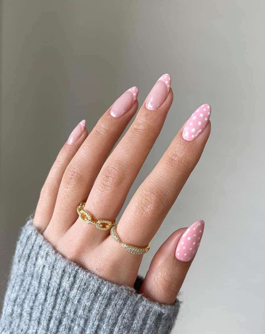 image of a hand with light pink nails with white polka dots