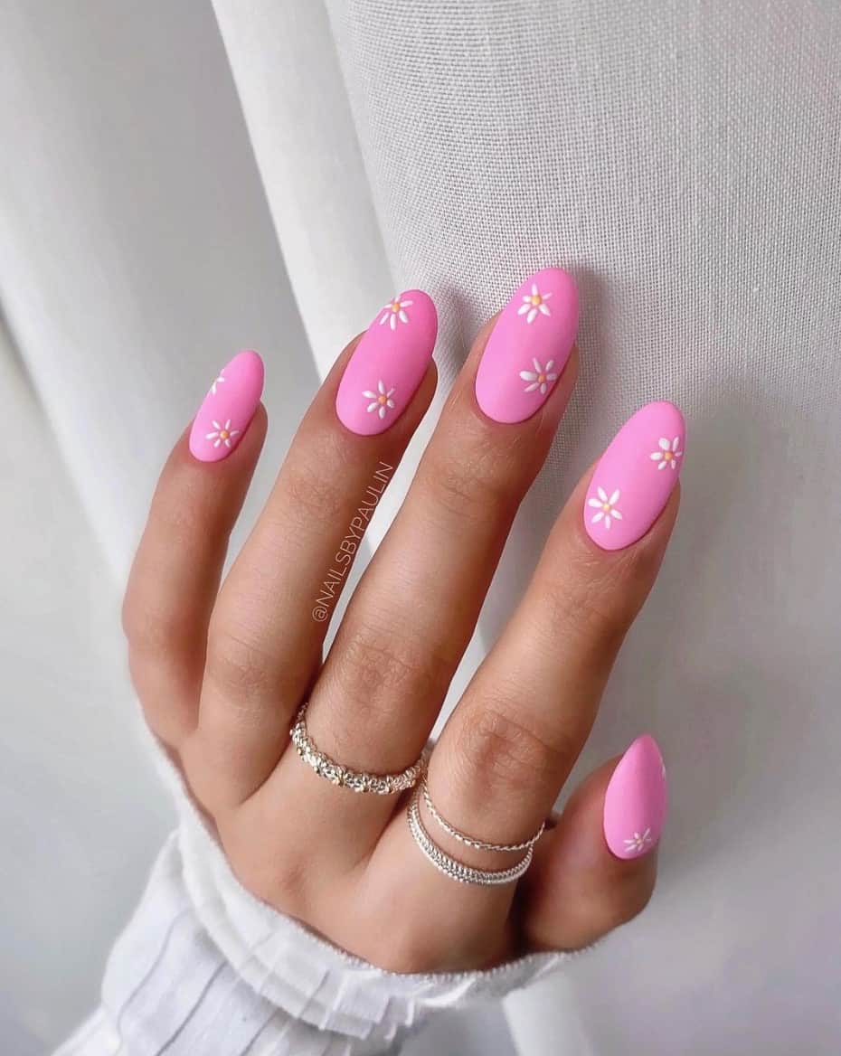 image of a hand with hot pink nails with white flower art