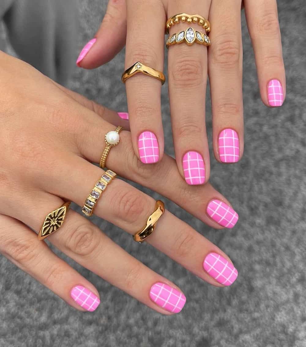 image of a pair of hands with hot pink and white plaid nail art