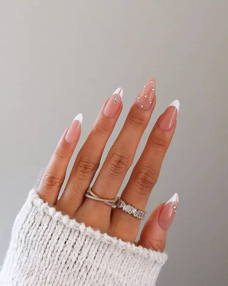 image of a hand with classic pink and white acrylic nails with a white french tip and jewel accents