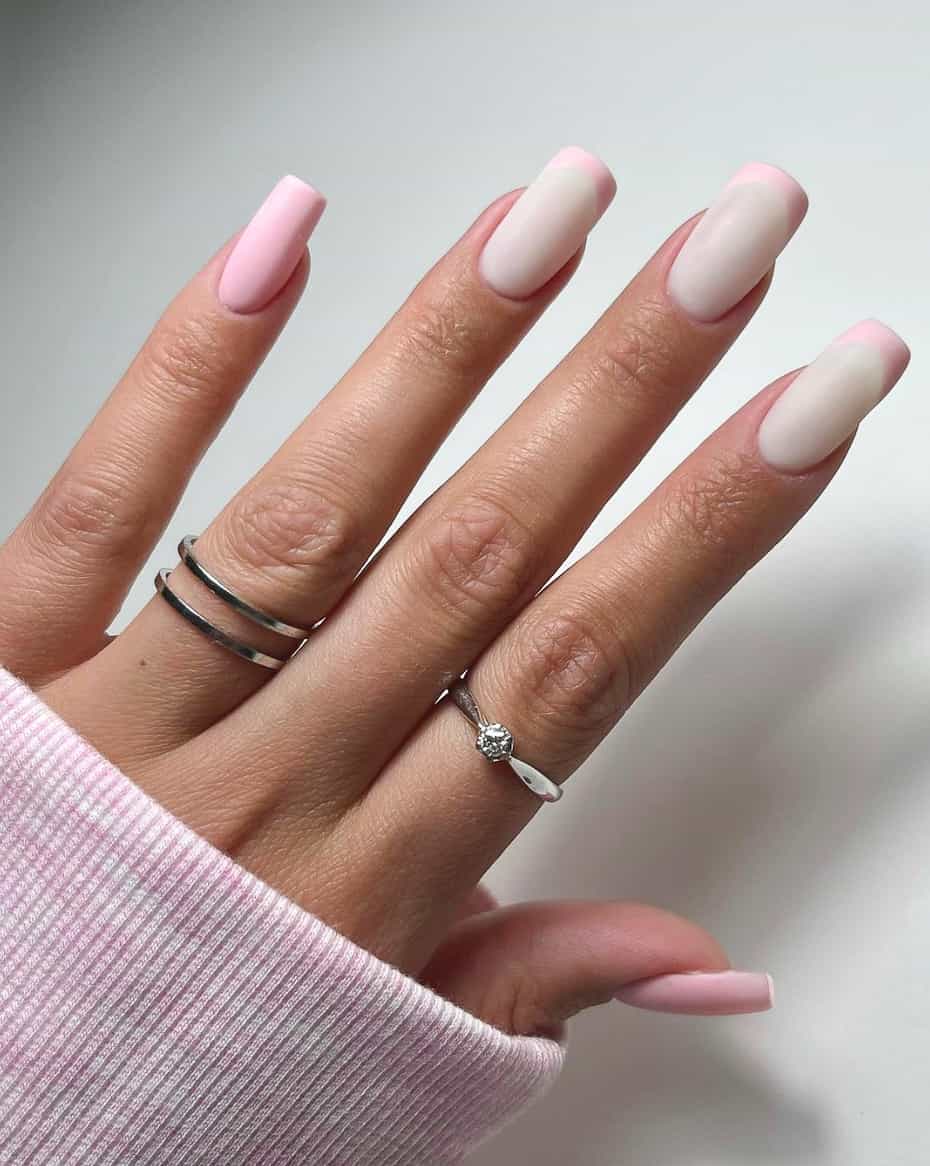 image of a hand with frosted white nails with light pink french tips and light pink accent nails