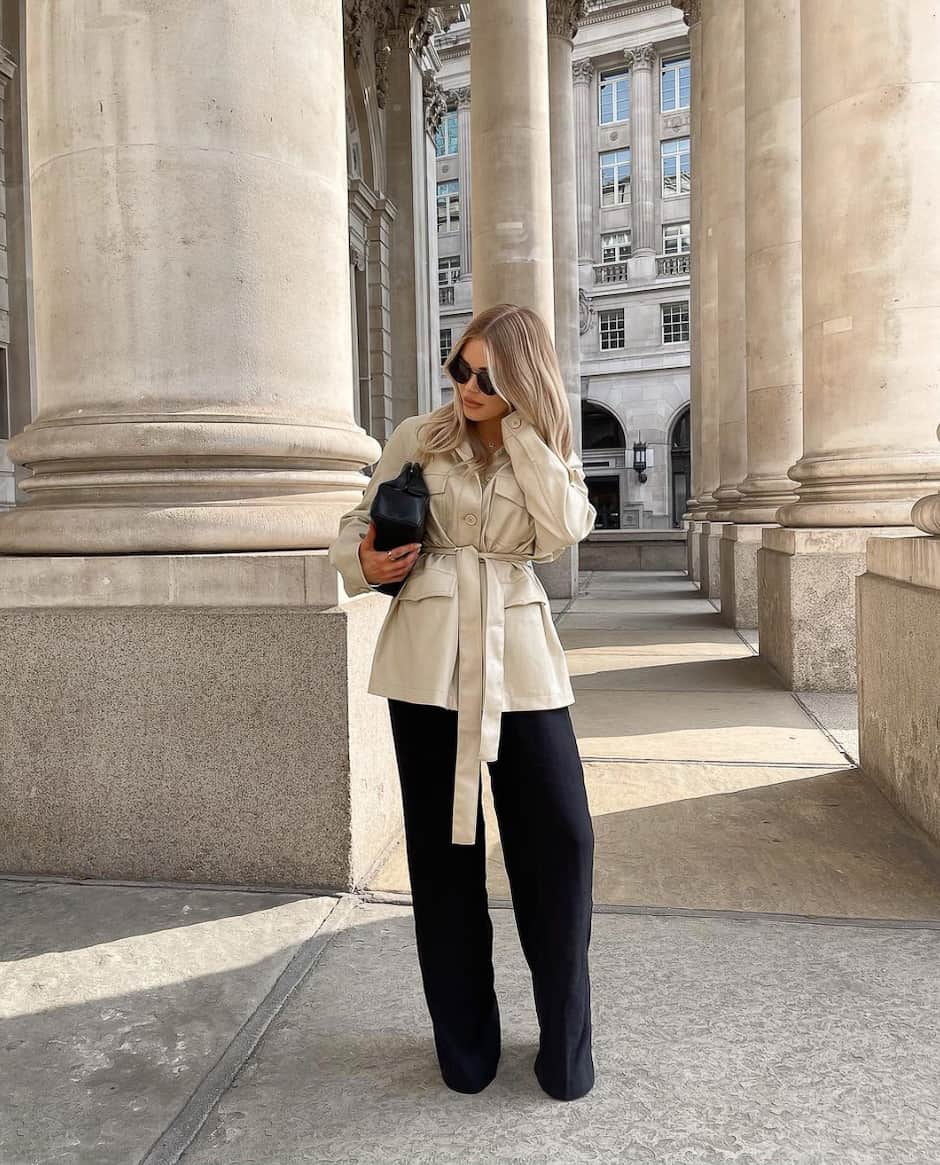 woman wearing a belted ivory leather shirt jacket with wide leg black pants 