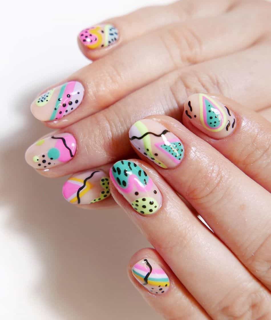 An image of a hand with colorful nails and geometric 90s nail designs