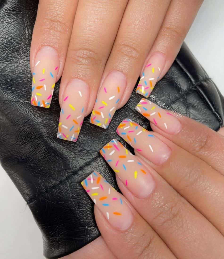 An image of a hand with long square nails with retro colorful confetti print