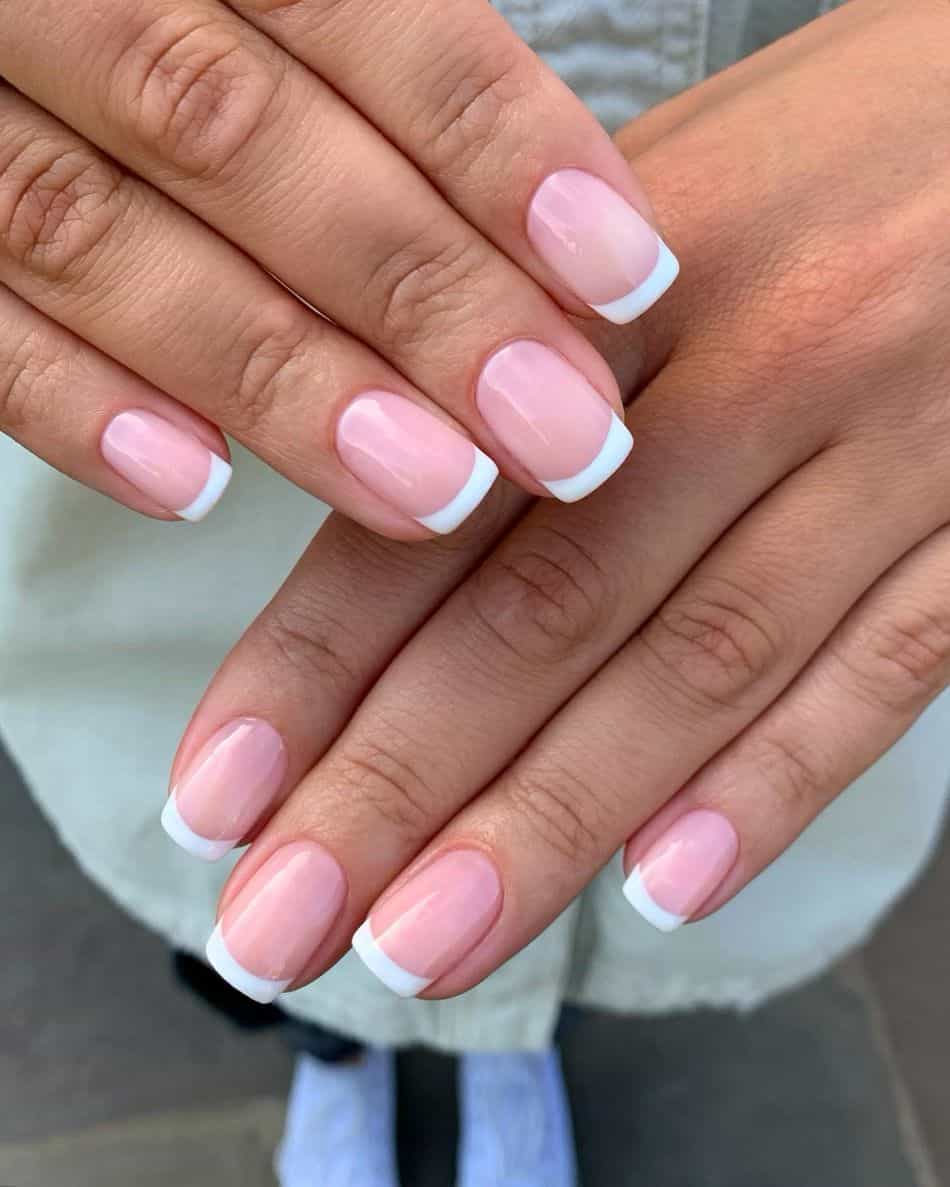 An image of a hand with classic square shaped French tips