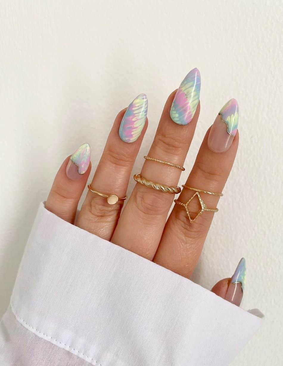 An image of a hand with 90s inspired pastel tie-dye nails and silver accents