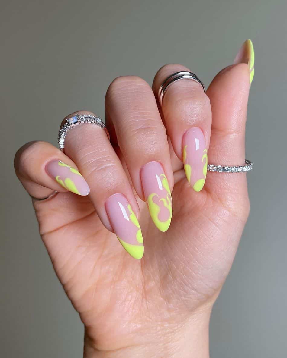 An image of a hand with neon yellow flame nail art