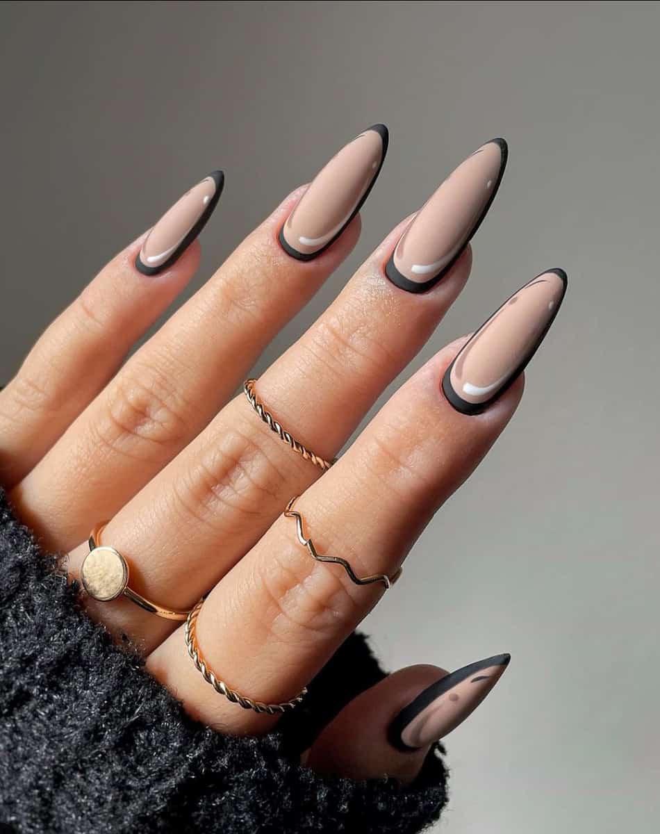 an image of a hand with beige comic style nails with black borders and a matte finish