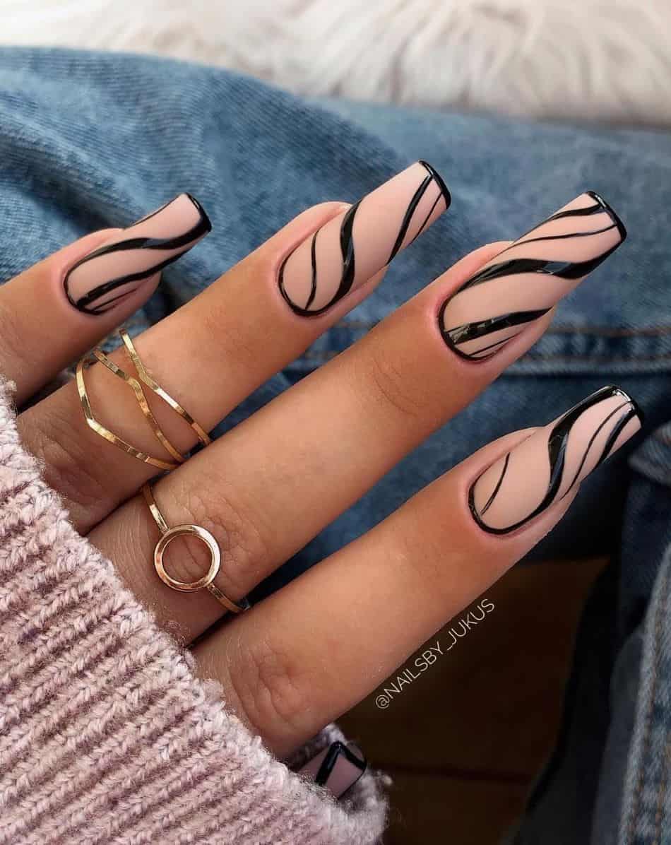 an image of a hand with long square nails with matte beige polish and wavy black lines