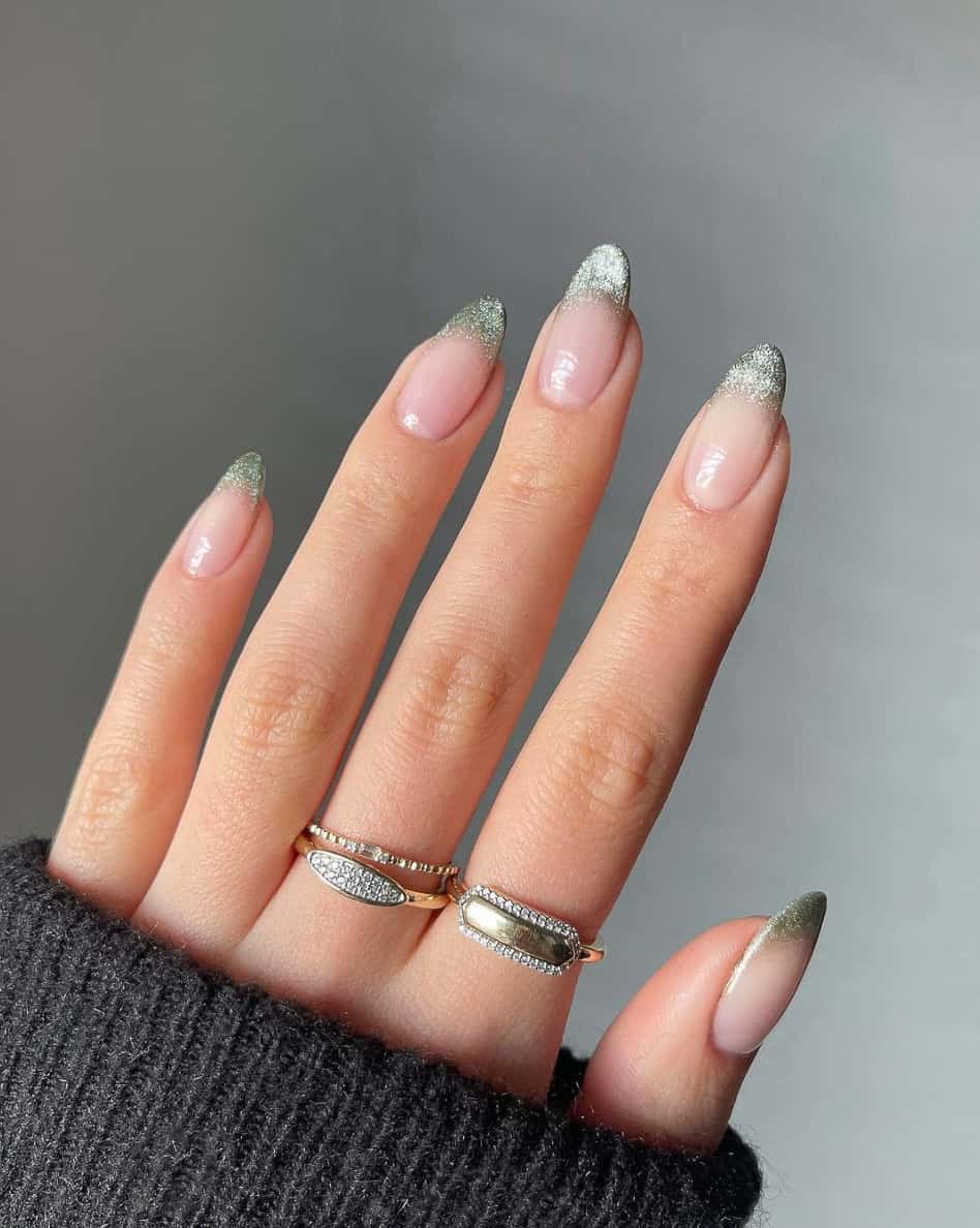 A hand with sage green shimmering French tips