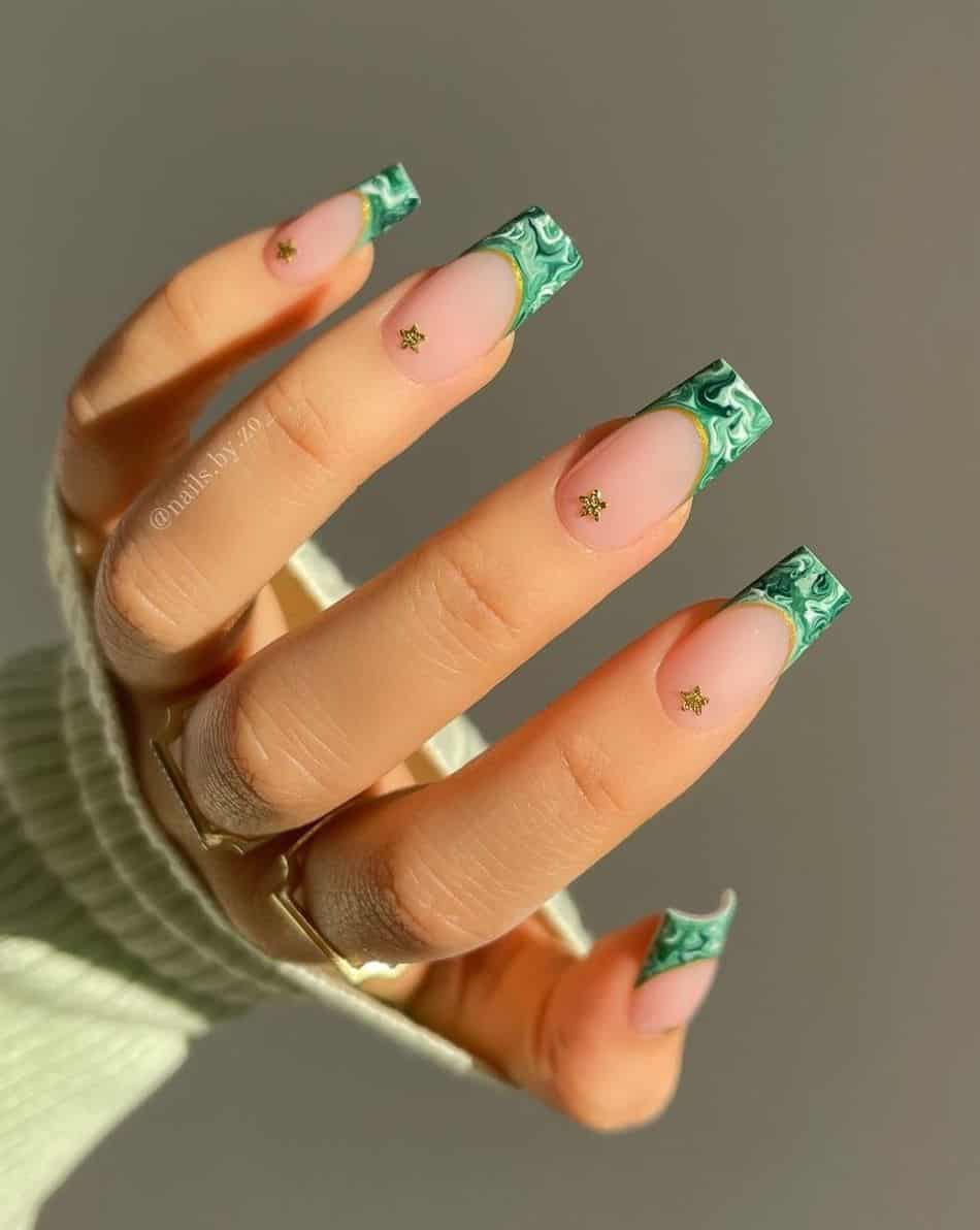 A hand with marbled green and white French tips and star accents