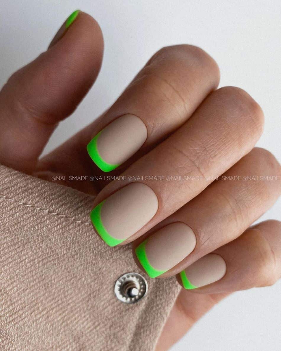 A hand with matte nude nails and matte lime green French tips