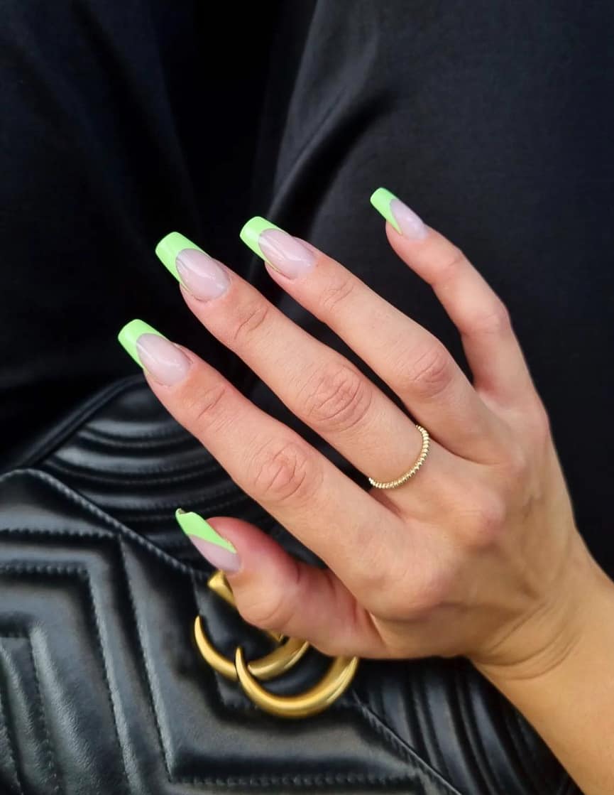 A hand with spring green French tips on long square nails