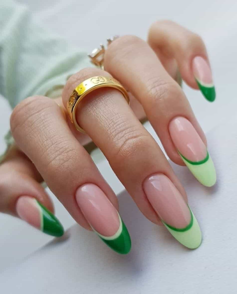 A hand with light and dark green French tips
