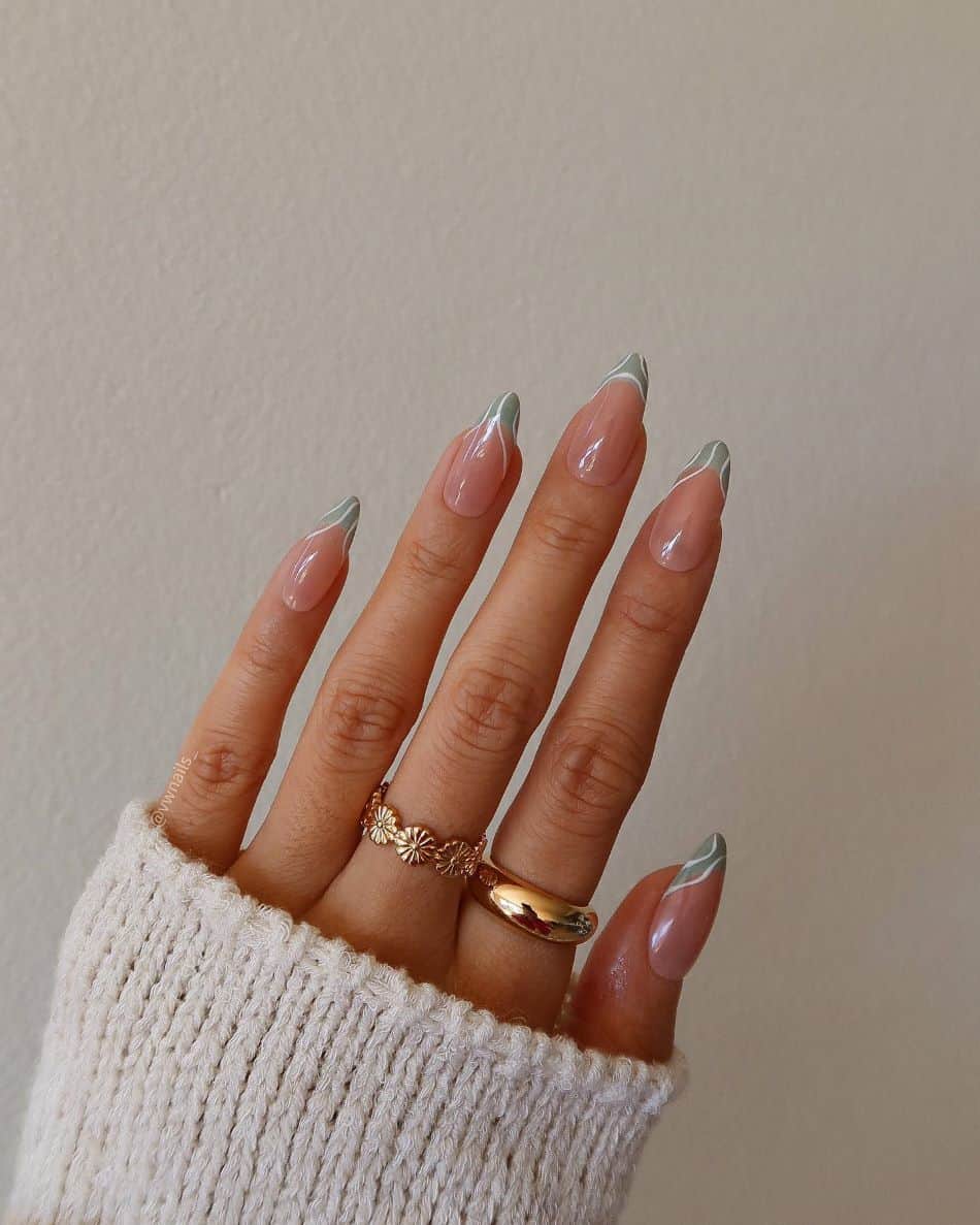 A hand with light green French tips and white wave accent lines
