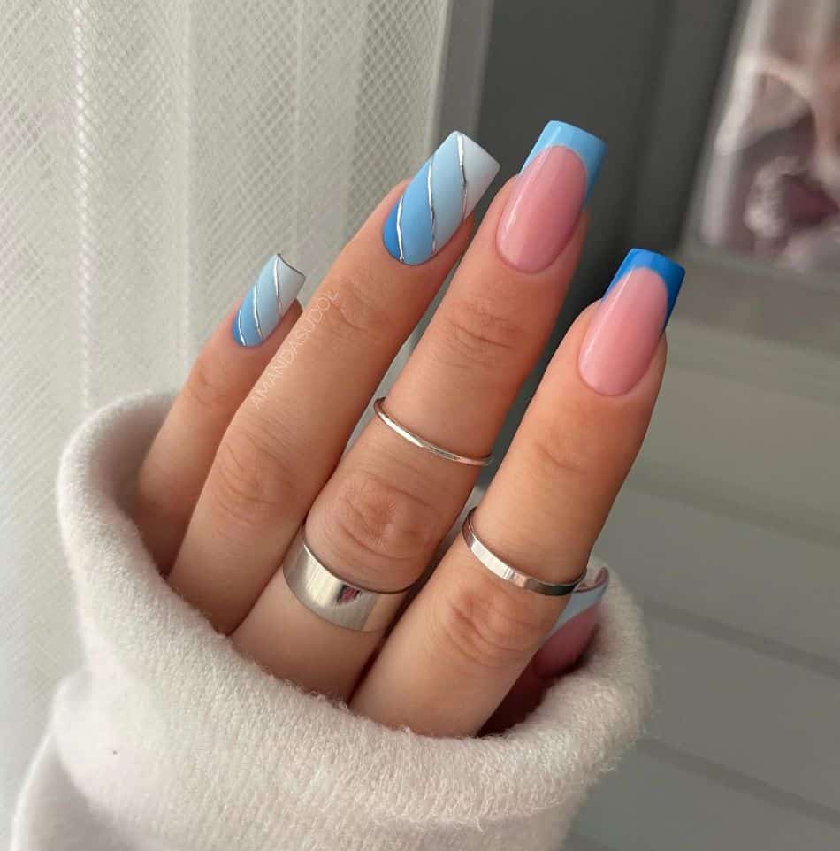 Ombre blue nails with French tip accent nails and silver details. 
