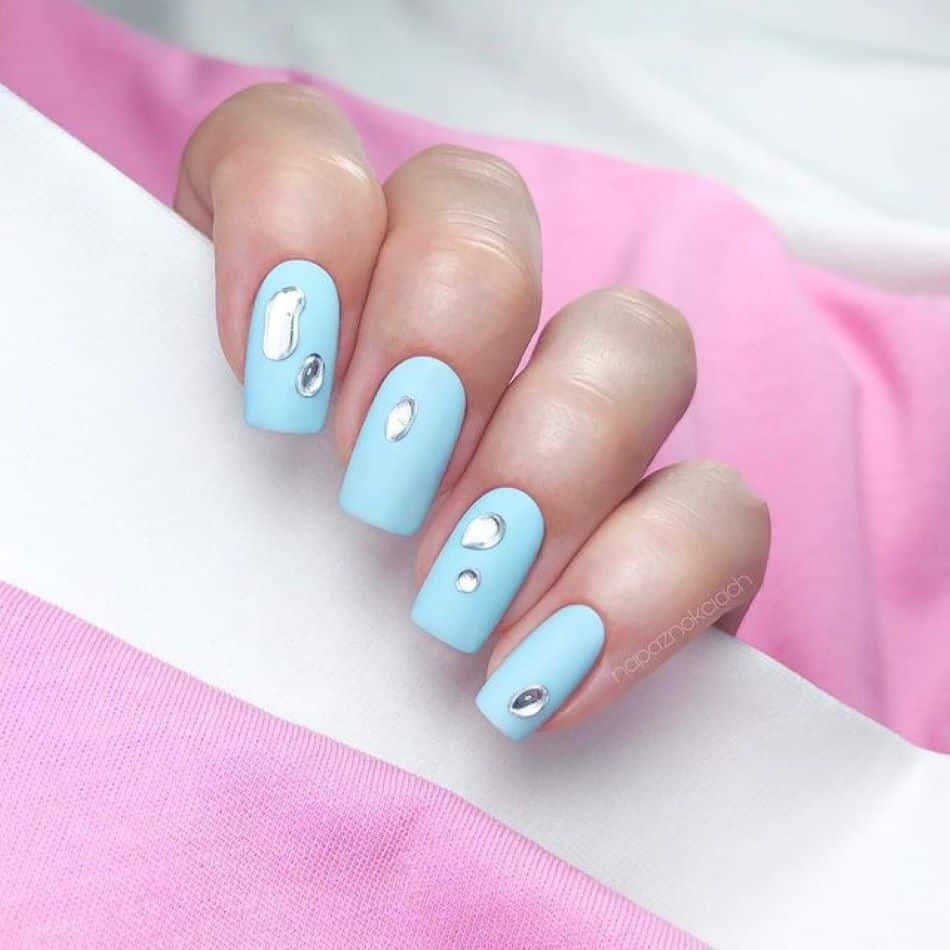 Sky blue nails with silver bead accents. 