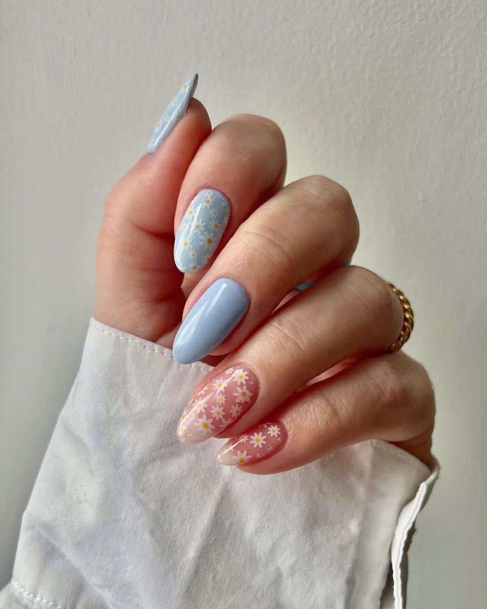 Pastel blue and nude almond nails with daisy nail art. 