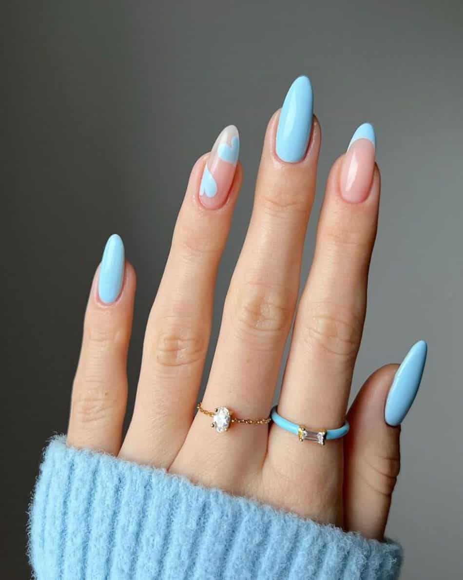 Solid blue manicure with French tip accent nail and heart details. 