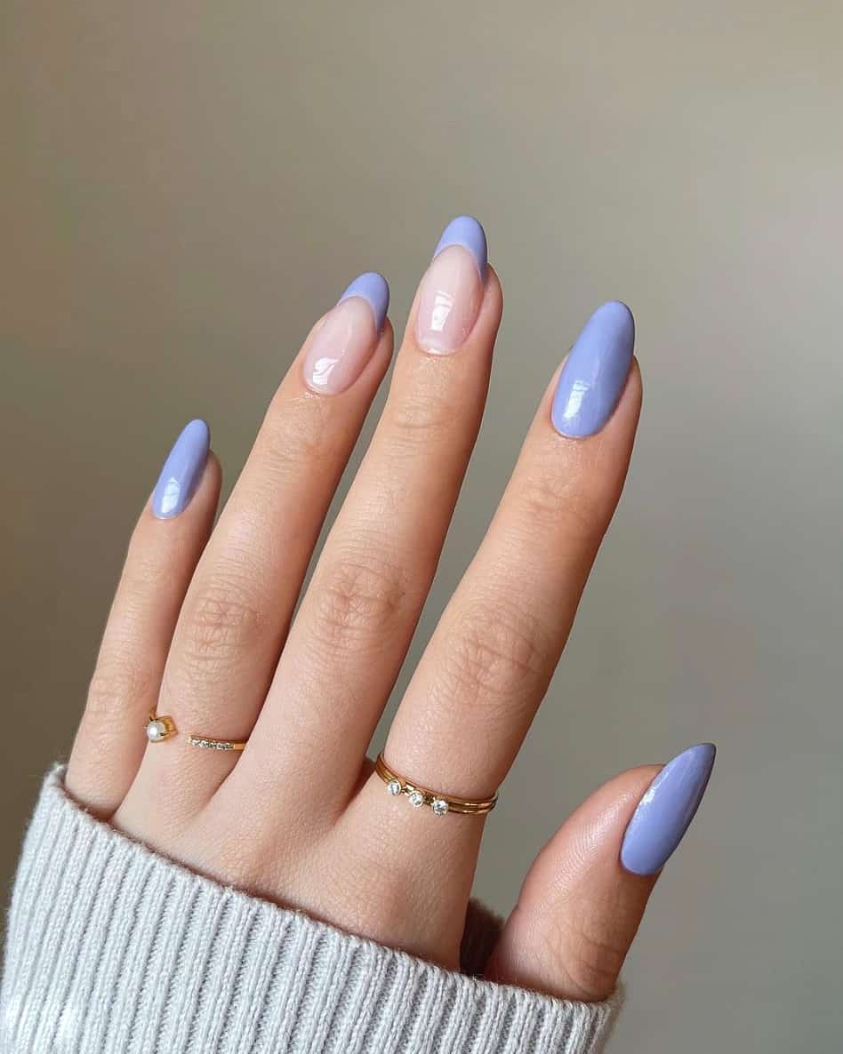A hand with solid-colored periwinkle nails and periwinkle French tip accent nails