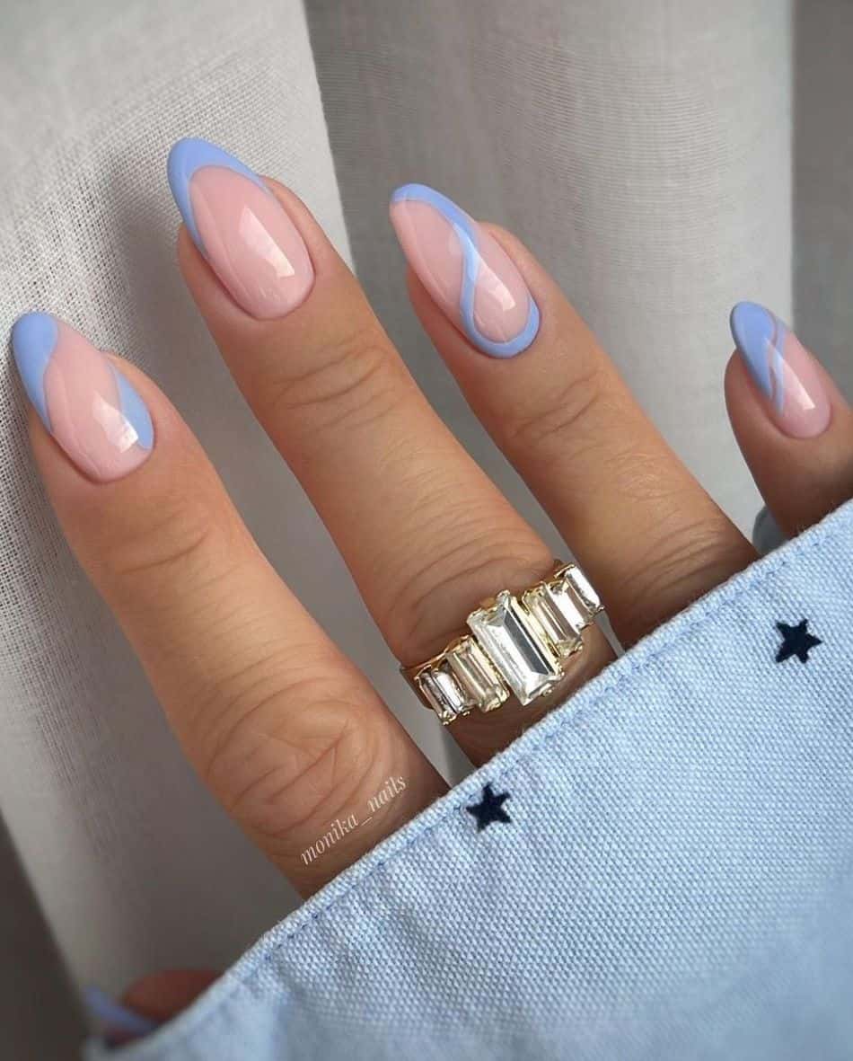 A hand with nude almond nails with periwinkle French tips and waves