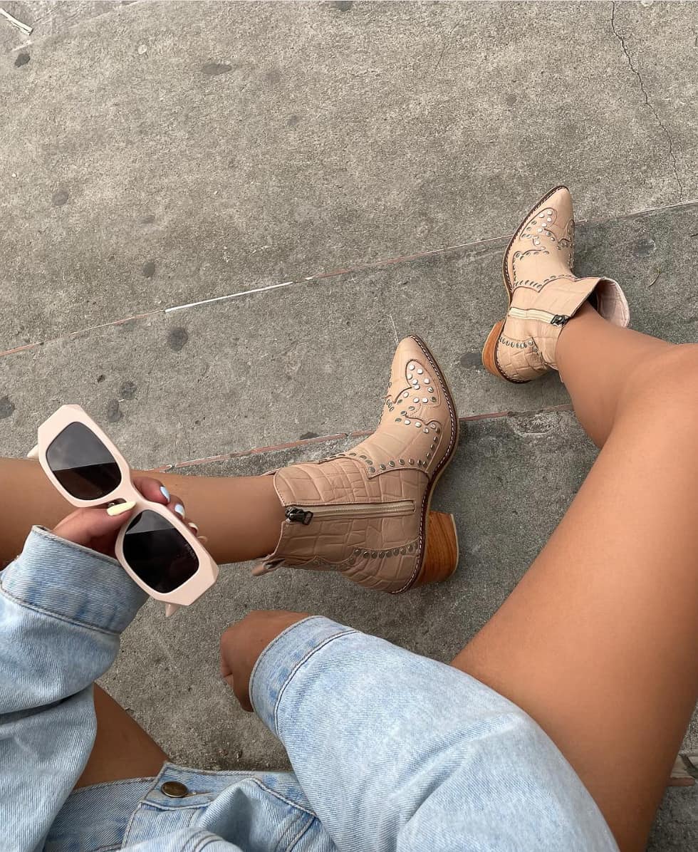 image of a woman wearing cowboy boots and a denim jacket 