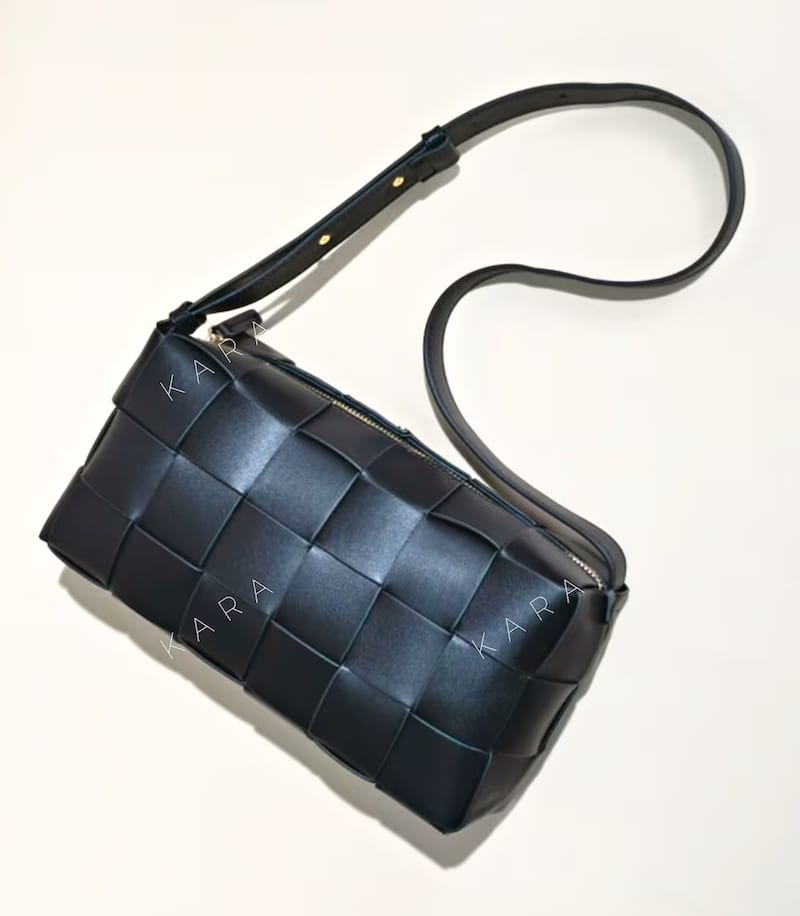 image of a black woven shoulder bag that is a dupe of the Bottega Veneta cassette bag