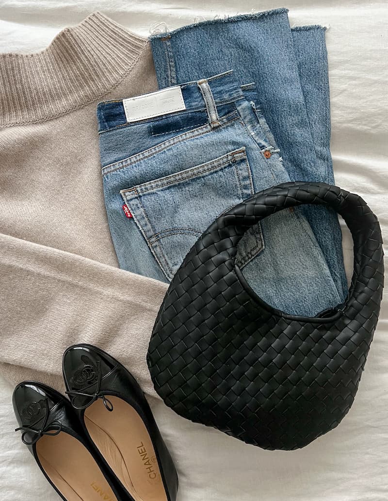 outfit flatlay with a beige sweater, re/done jeans, a black Bottega Veneta jodie bag dupe and black Chanel ballet flats