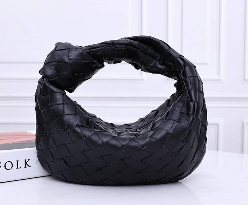 image of a black woven leather hobo bag with a handle with a knot detail