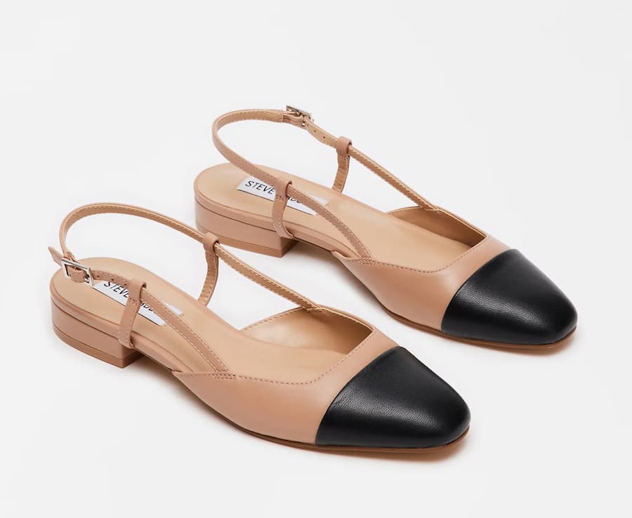 image of a pair of beige slingback low heels with a black cap toe