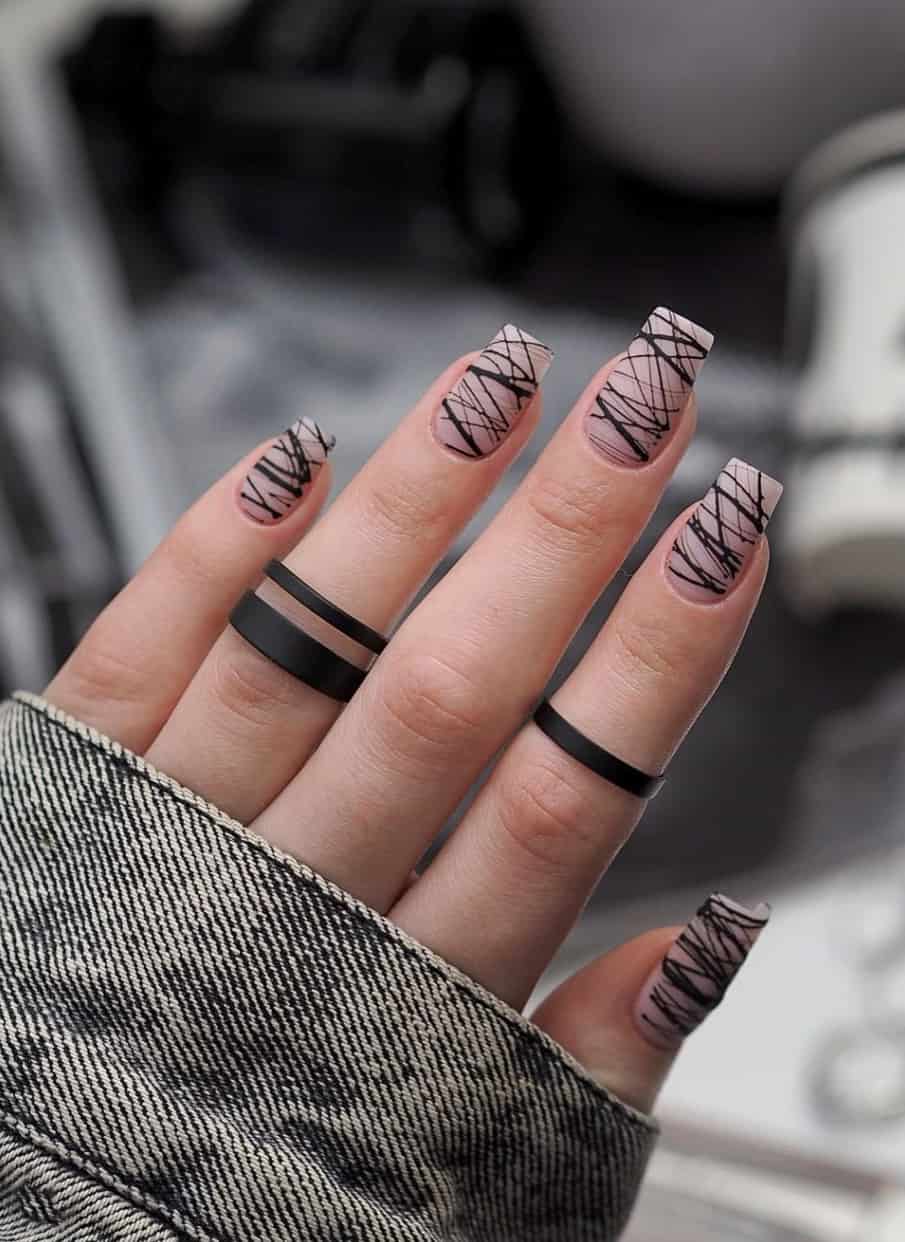 A hand with matte square nails and horizontal black line art