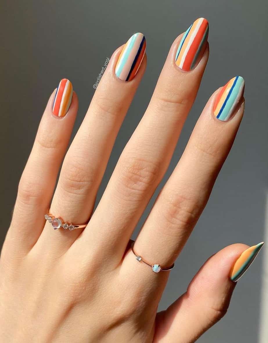 A hand with almond nails painted in colorful vertical lines