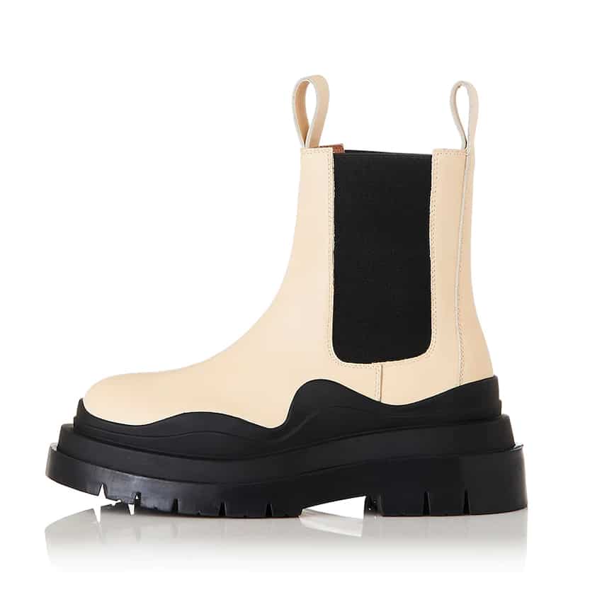 image of a lug boot in cream leather with a thick black sole with wave detail