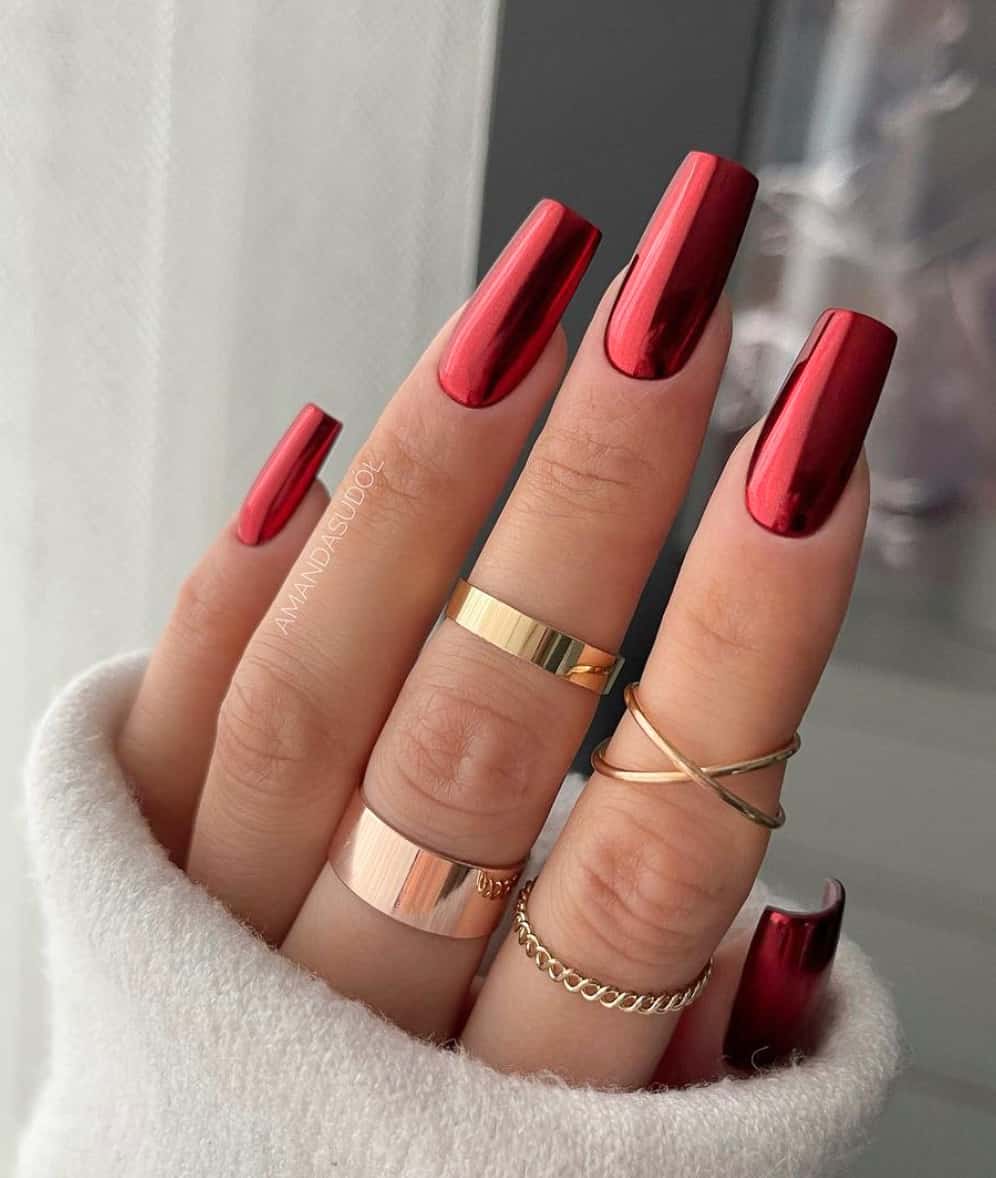A hand with medium-length square nails with metallic red polish