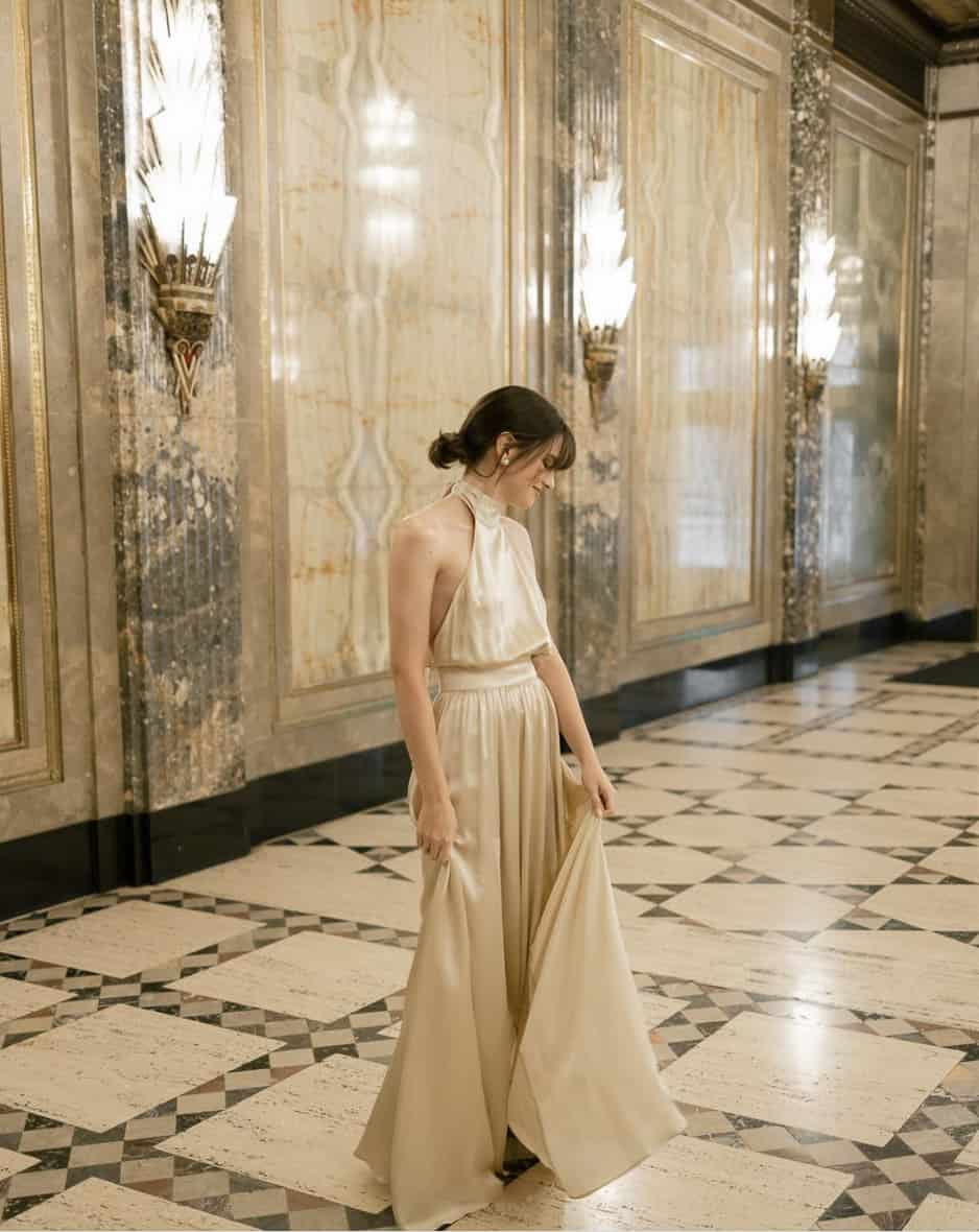 woman wearing a long champagne gold gown with a halter neck for a gala