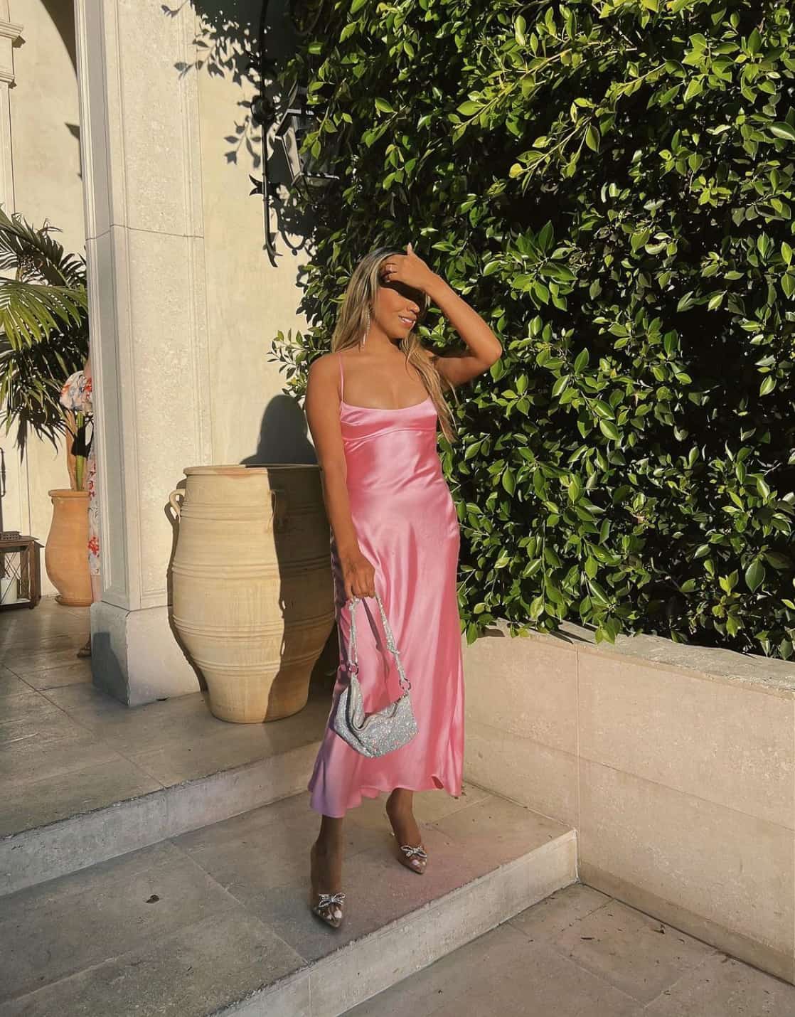 woman wearing a light pink slip dress with heeled sandals