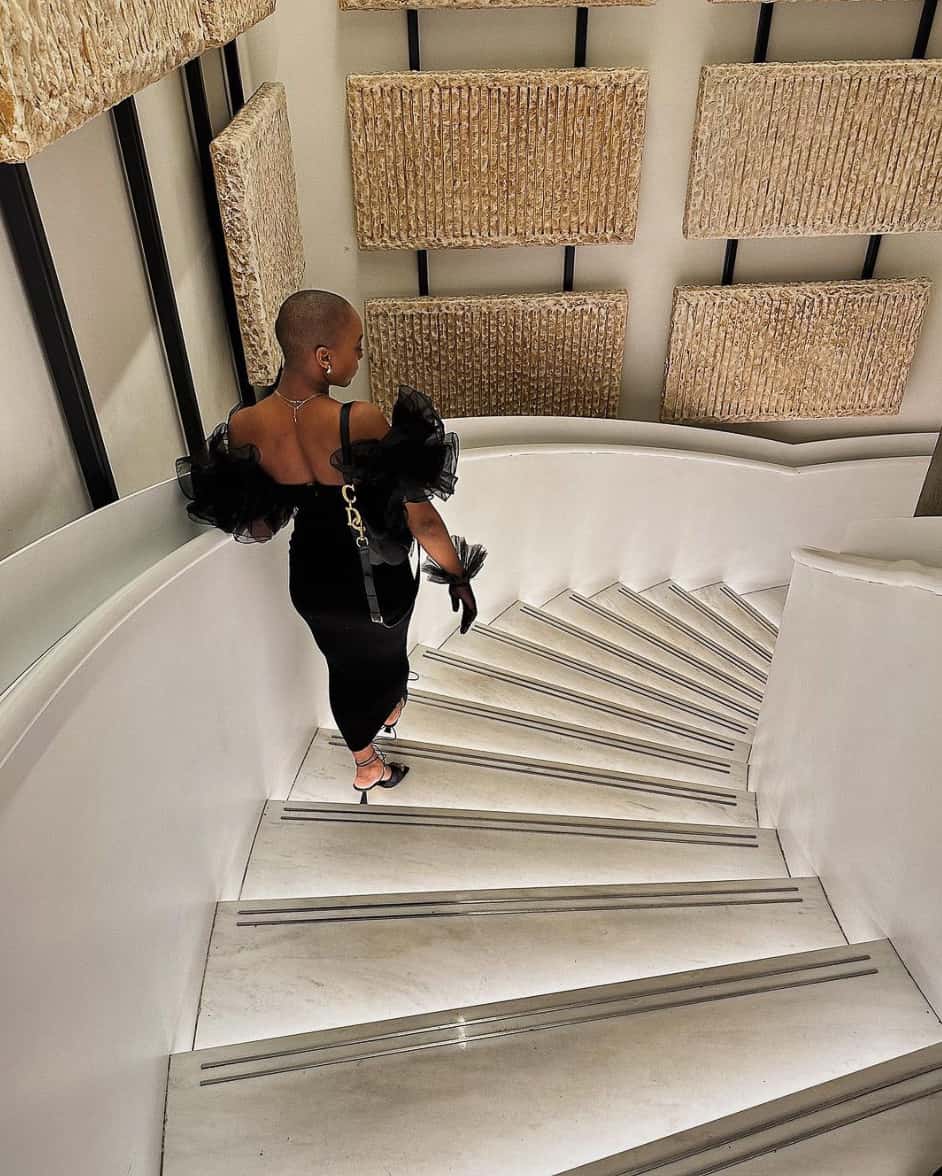 stunning black woman wearing a black evening gown with ruffled puff sleeves