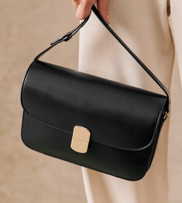image of a black box bag with gold hardware clasp in the center