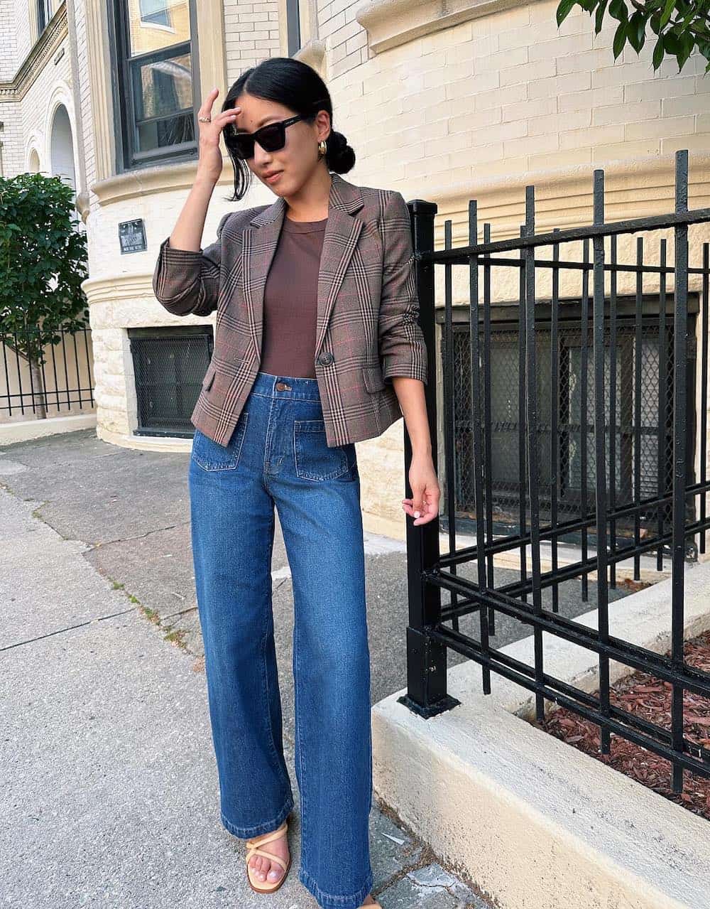 woman wearing a brown blazer over a brown top with wide leg blue jeans