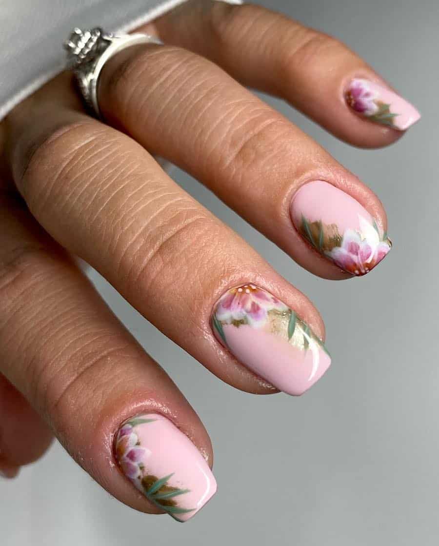 image of a hand with light pink polish and floral nail art