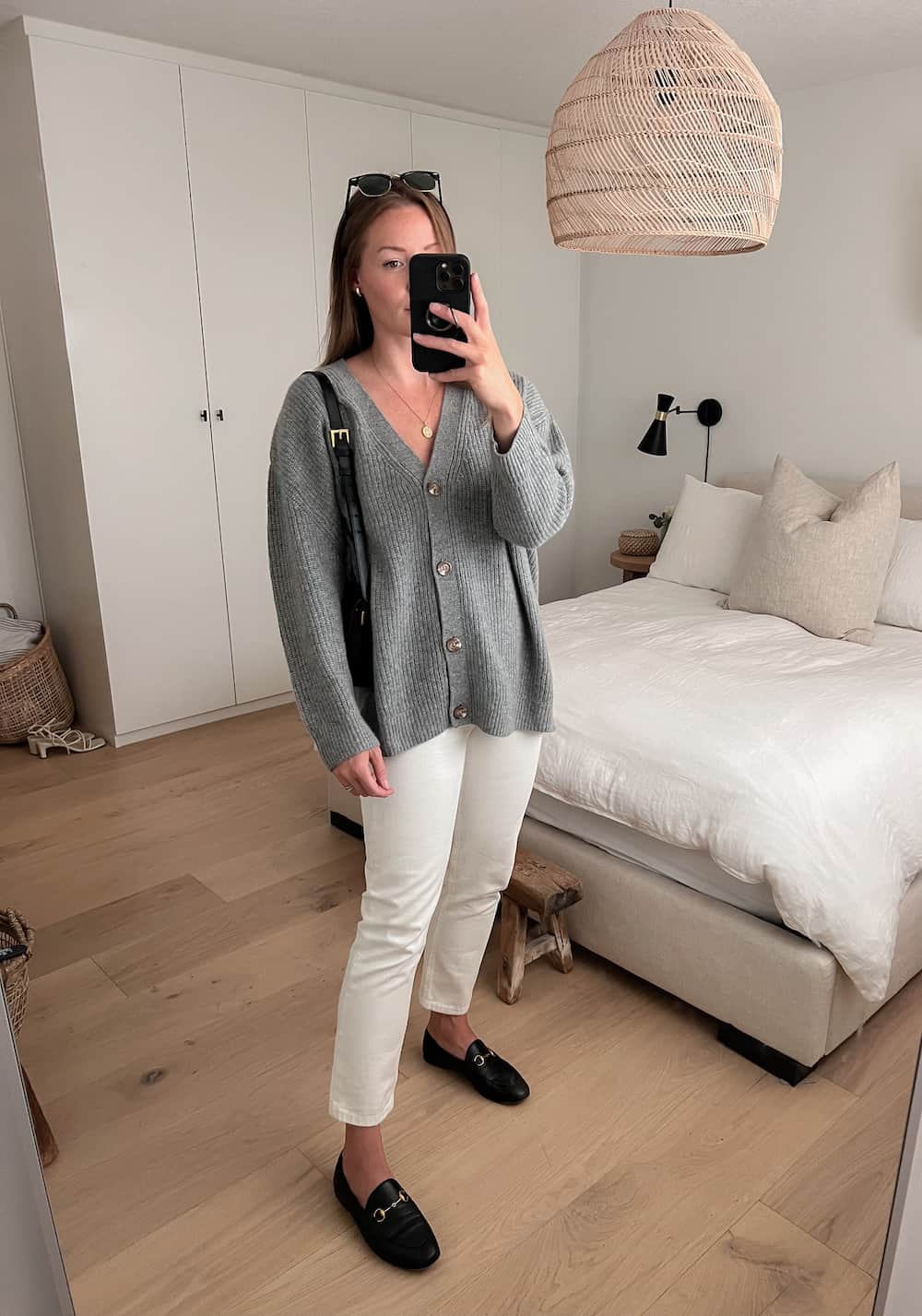 Christal wearing an oversized grey Quince cardigan with white jeans and black loafers as part of a fall capsule wardrobe 