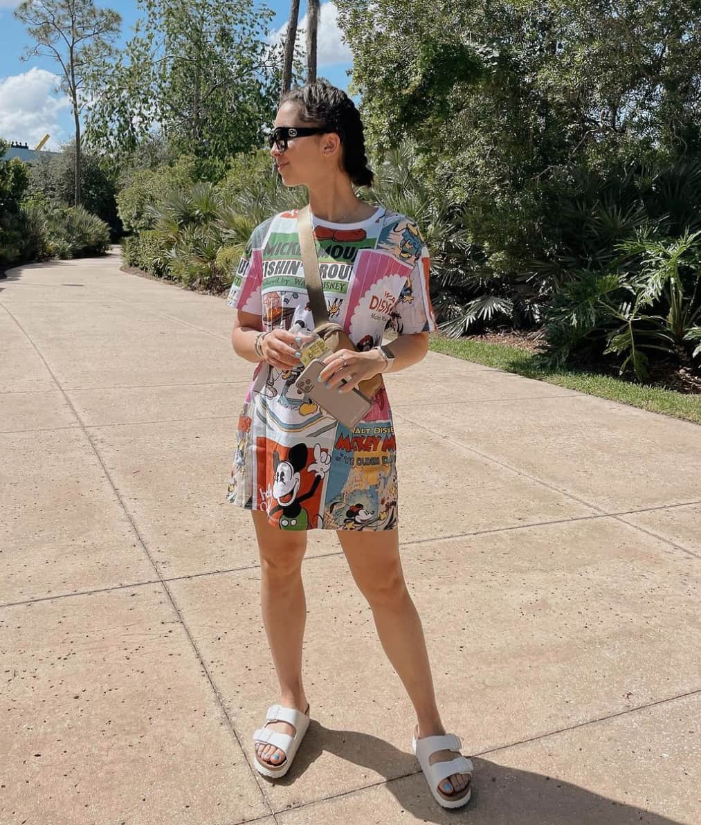 Woman wearing a Disney t-shirt dress with sandals at Disney World