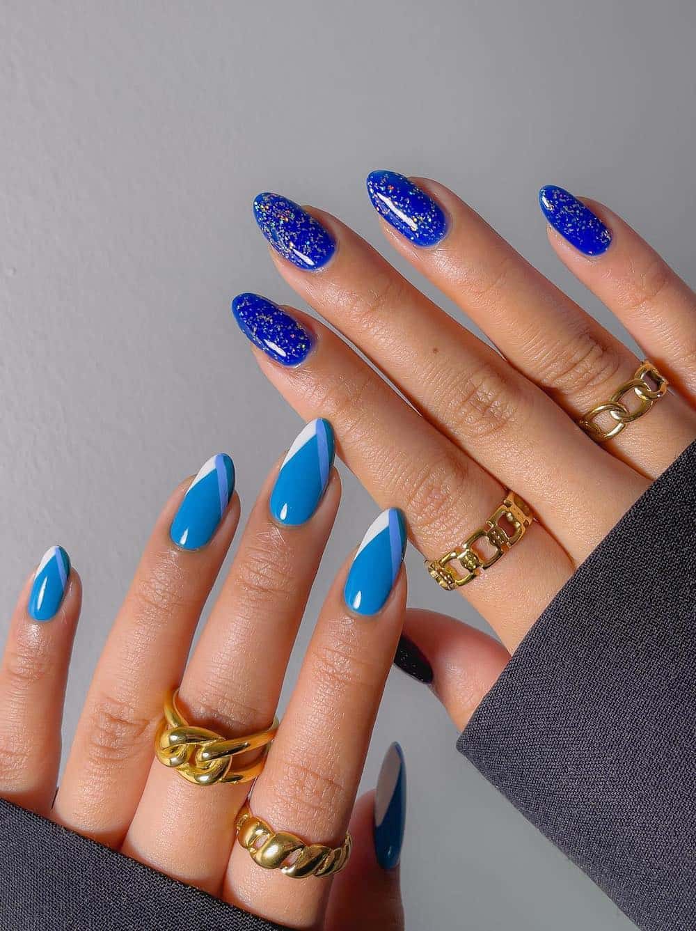 image of a pair of hands with dark and medium blue graduation nail designs