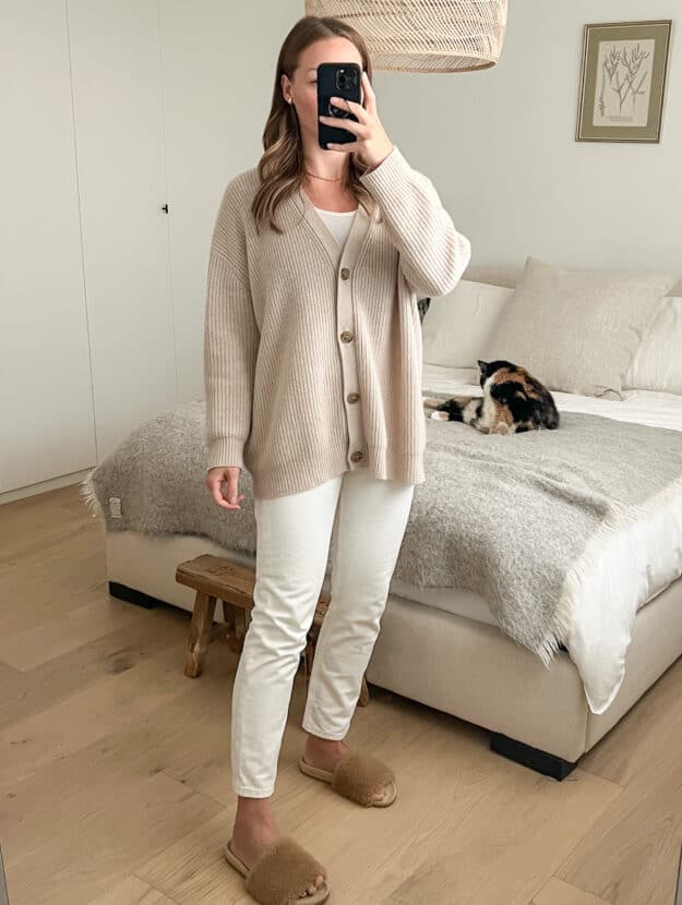 Christal wearing the Jenni Kayne cashmere cocoon cardigan in Oatmeal with white jeans and shearling slides