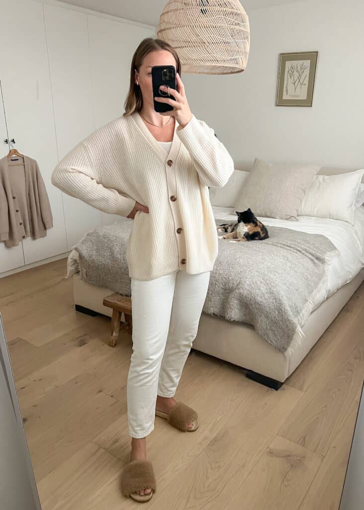 Christal wearing the Quince cashmere boyfriend cardigan in Ivory with white jeans and shea