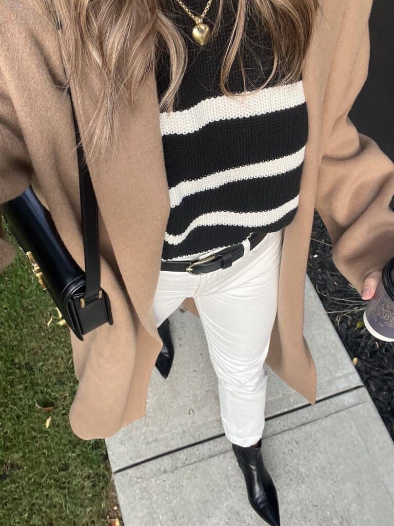Christal wearing a camel Jenni Kayne cashmere overcoat with a striped black sweater and off-white jeans