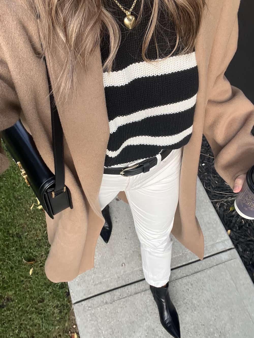 Christal wearing a camel Jenni Kayne cashmere overcoat with a striped black sweater and off-white jeans