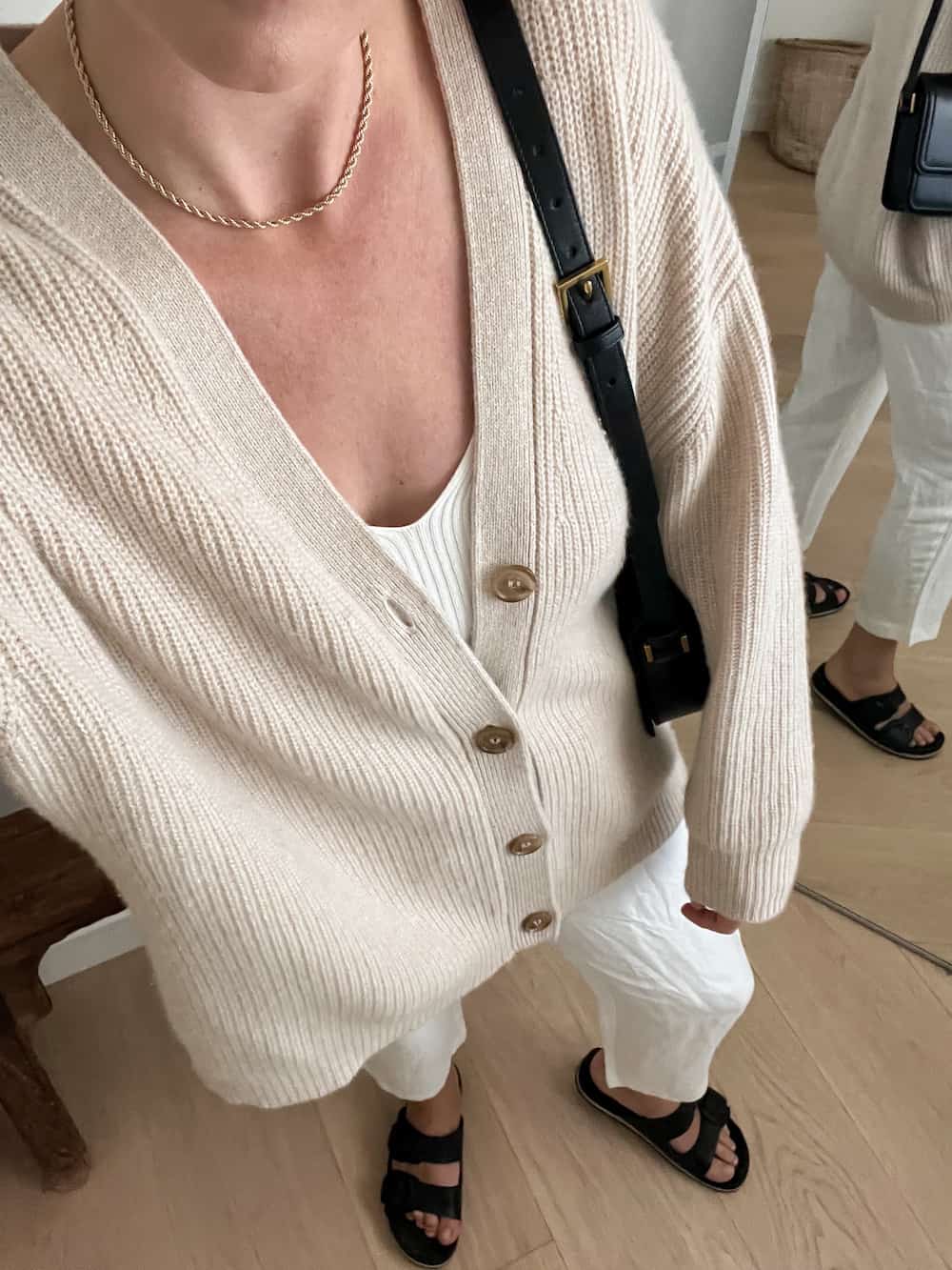 Christal wearing an oatmeal oversized cashmere cardigan from Jenni Kayne with white linen pants and black sandals
